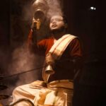 A priest performing a ritual with smoke and light in Varanasi, India.